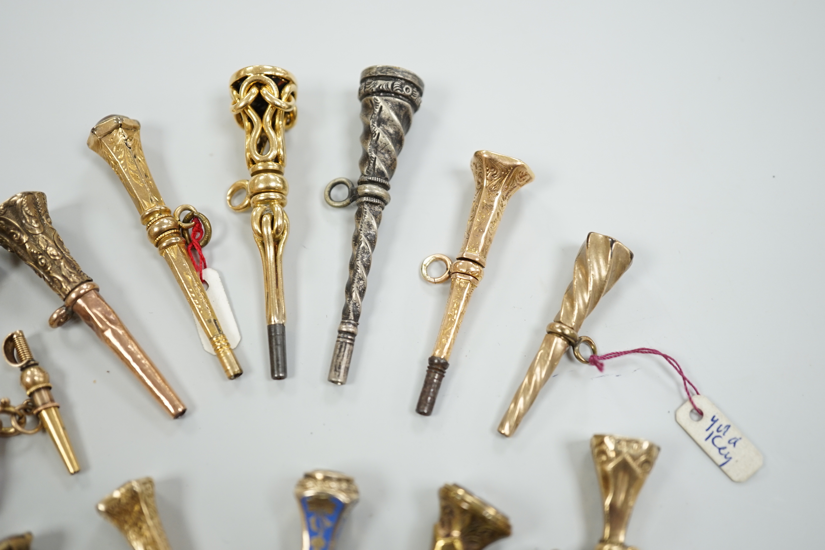 Fifteen assorted 19th century mainly yellow metal overlaid and gem set watch keys, including bloodstone, citrine and white chalcedony and one with enamel, mostly of trumpet form, largest 51mm.